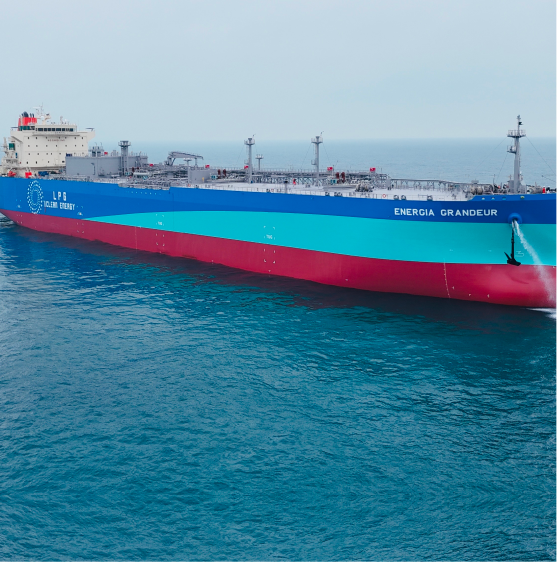 A large LPG tanker ship named "Energia Grandeur" with a red and blue hull floats on calm blue seas under a clear sky, conveying serenity and strength.