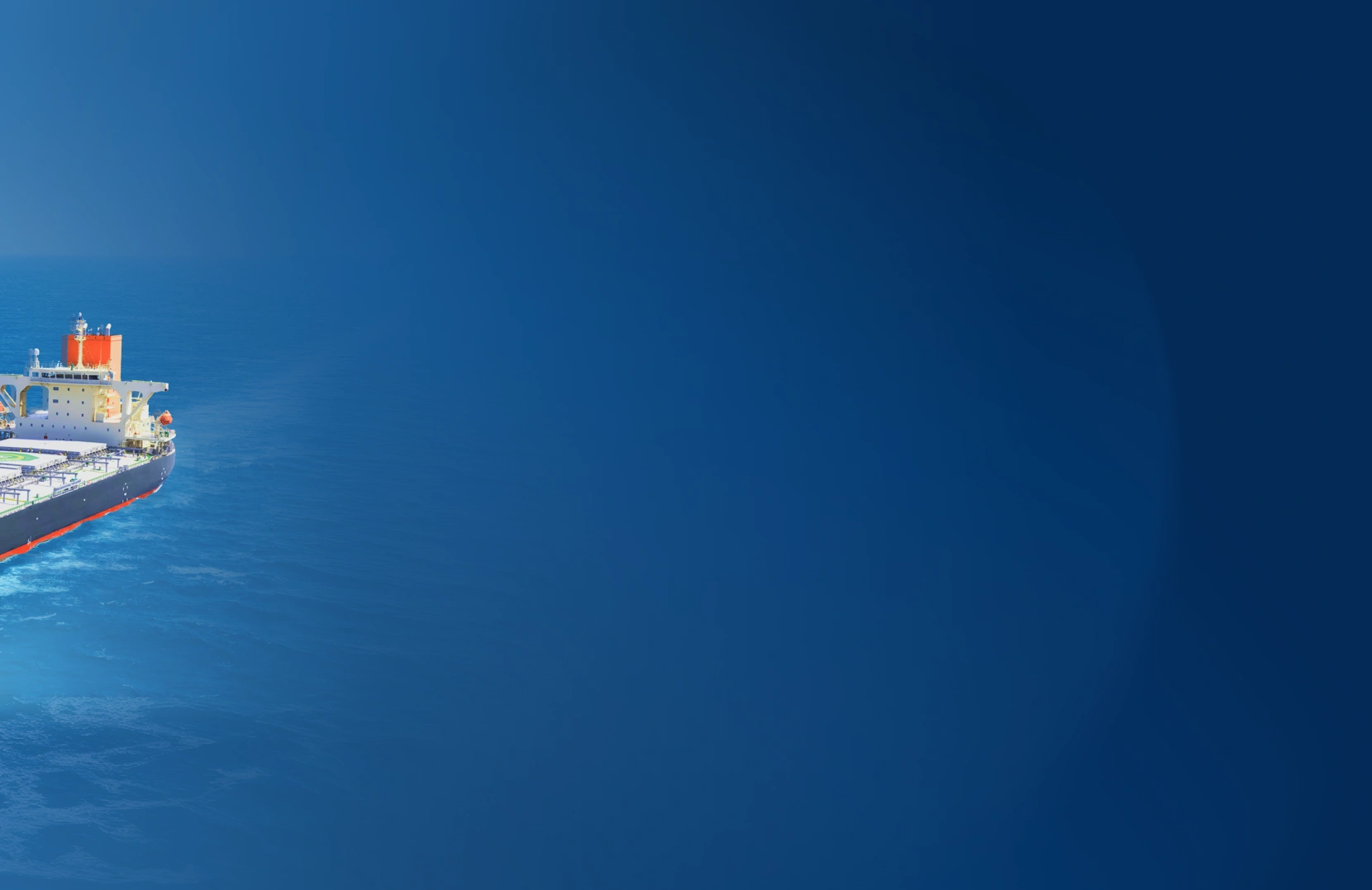 A cargo ship sails the ocean with a large white sail structure at the bow. The scene conveys innovation in maritime transport against a bright blue sea.