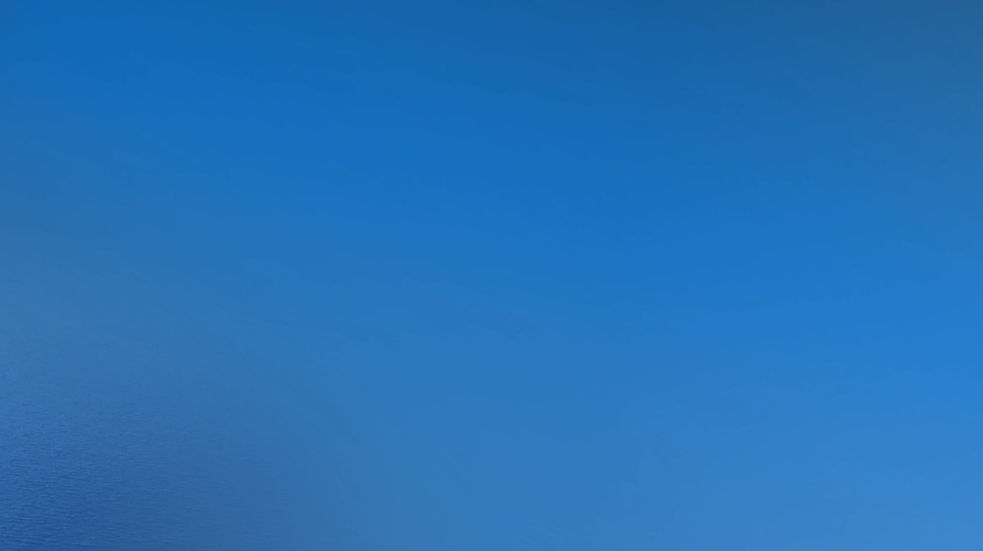 A clear blue sky with a smooth gradient from a lighter blue at the bottom left corner to a deeper blue at the top right, with no visible clouds or objects.